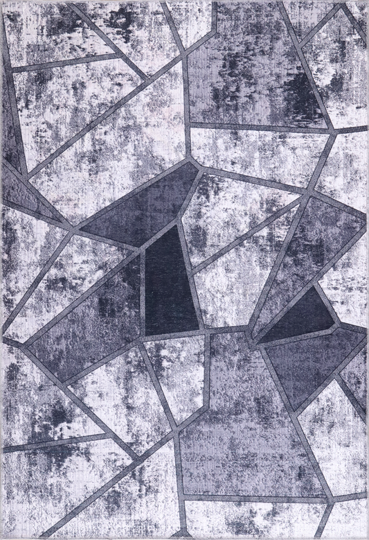 Geometric patterned rug with black and gray shapes on a textured background